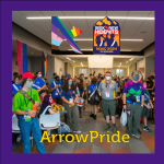 A group of people wearing colorful Scout uniforms gather in a room decorated with pride flags and banners for NOAC 2024 at CU Boulder. The top banner reads “Seek New Heights” and the bottom text reads “ArrowPride.” Many attendees are wearing face masks.